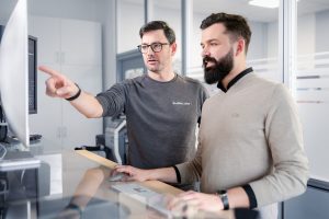 Businessfotos Düsseldorf 13 Zwei Mitarbeiter arbeiten gemeinsam an einem Computerarbeitsplatz, Businessfotografie Köln