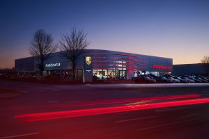 Businessfotos Düsseldorf 8 Außenaufnahme des Porsche Zentrum Soest bei Nacht mit Lichtspuren, Unternehmensfotografie