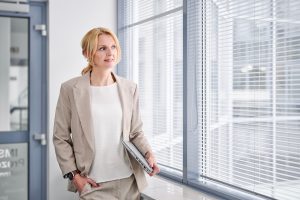 Businessfotos Düsseldorf 11 BBusinessportrait einer Geschäftsfrau mit Laptop am Bürofenster, Unternehmensfotografie Köln