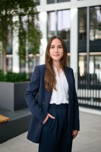 Halbkörperportrait einer Rechtsanwältin in Business-Outfit vor einer Glasfassade in Köln