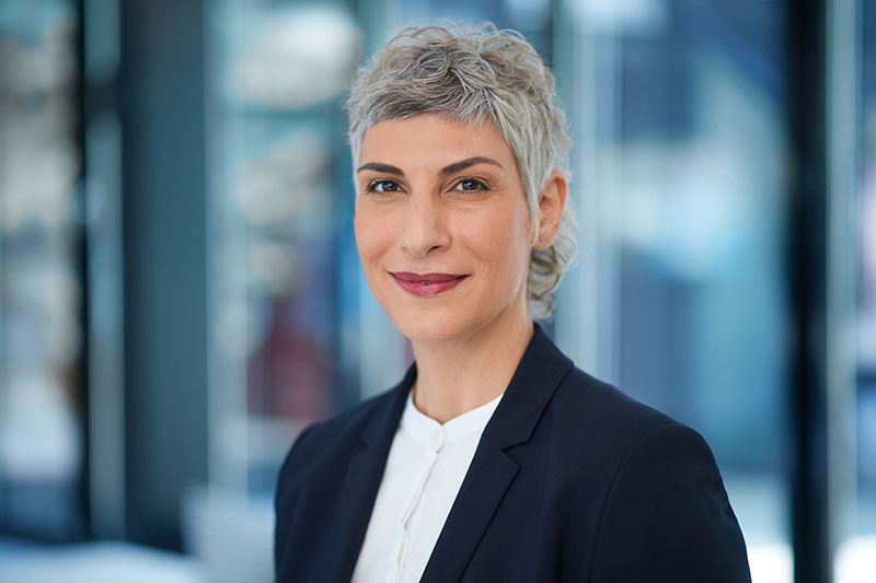 Home 5 Professionelles Mitarbeiterfoto einer Frau im Business-Outfit in einem modernen Gebäude
