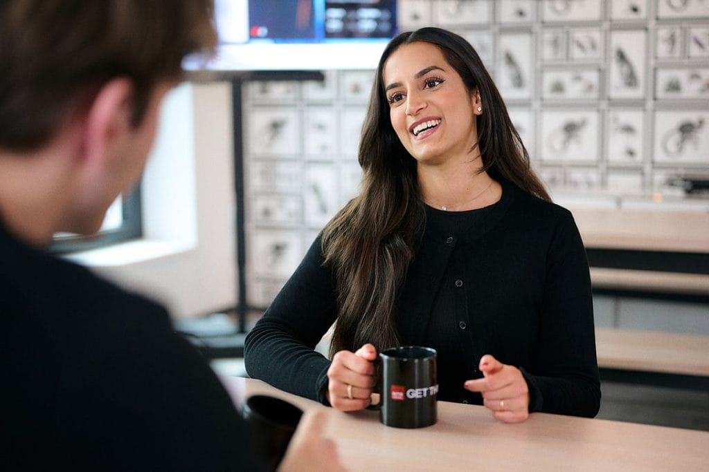 Businessfotos für Rechtsanwälte, Kanzleien und Steuerberater 7 Eine Rechtsanwältin sitzt mit einem Kollegen in der Kaffeeküche der Kanzlei und lacht